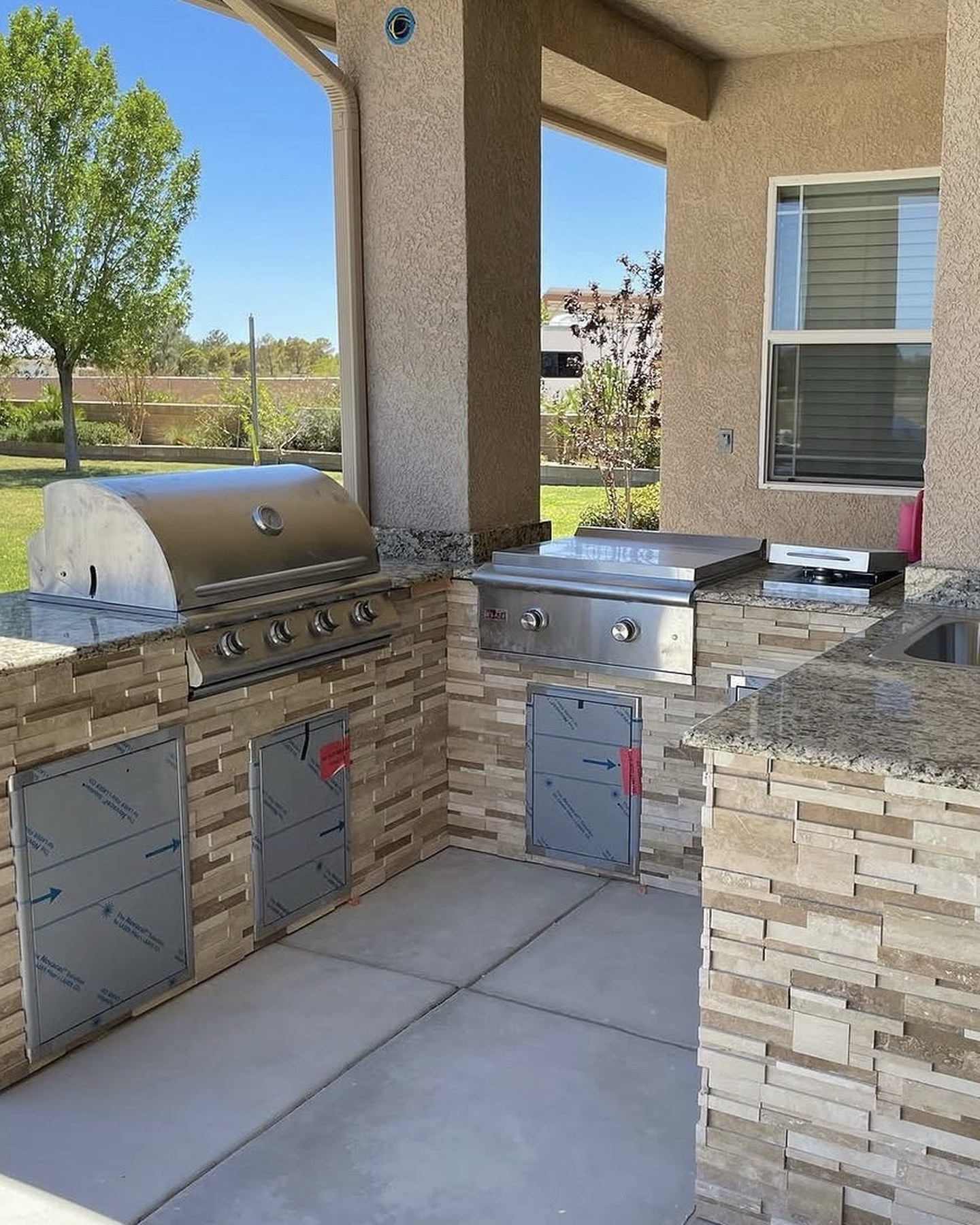 Outdoor kitchen with built-in grill, side burner and granite counters